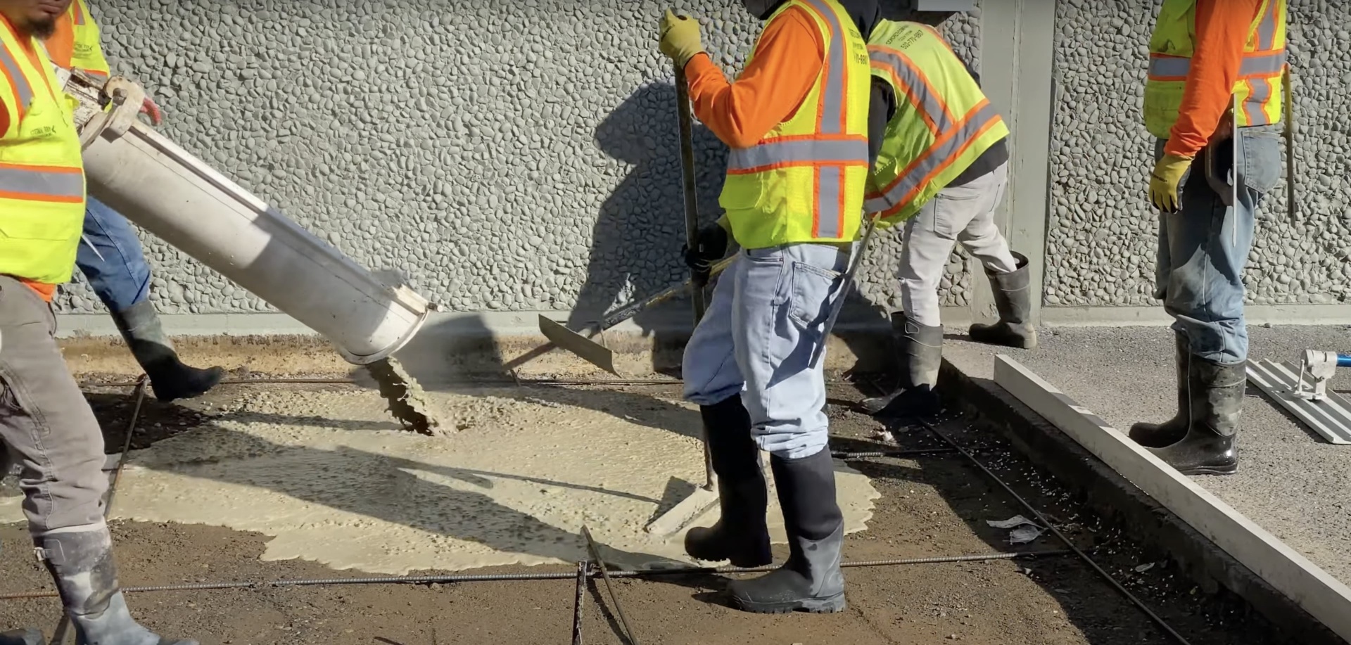 Evans Concrete Pros team using professional equipment for quality concrete installation Professional concrete workers pouring and finishing concrete with precision equipment